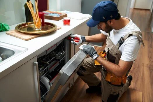Technician using a screwdriver on an open dishwasher