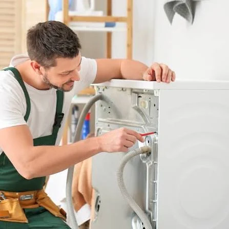 Technician repairing the rear panel and hoses of a washing machine